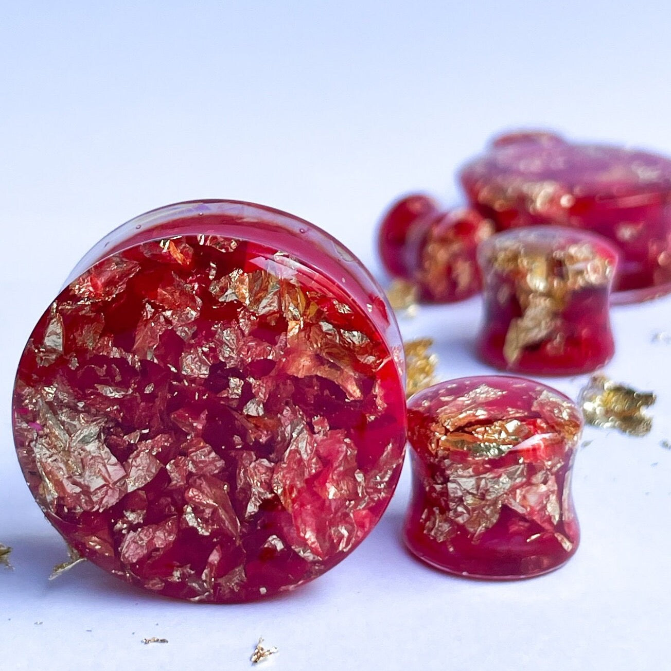 Red resin with gold colour flakes ear gauges