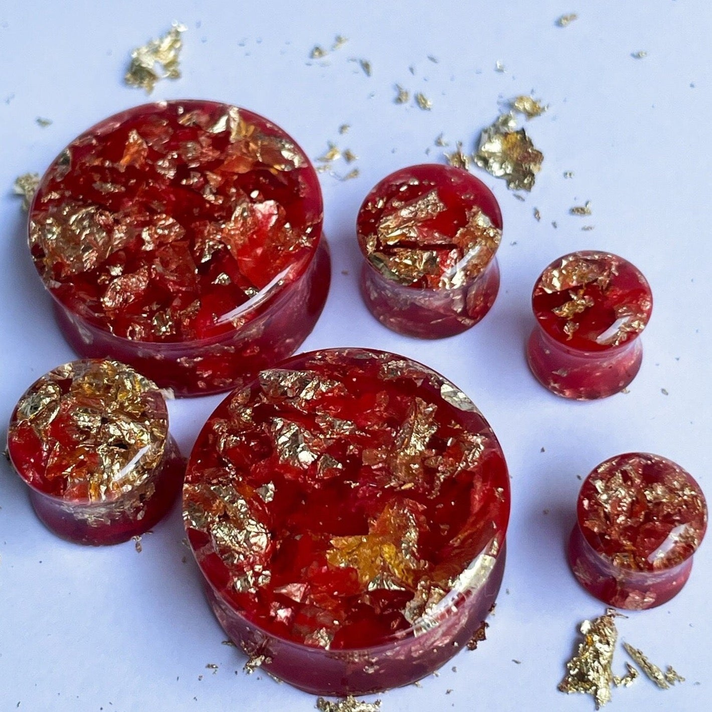 Red resin with gold colour flakes ear gauges