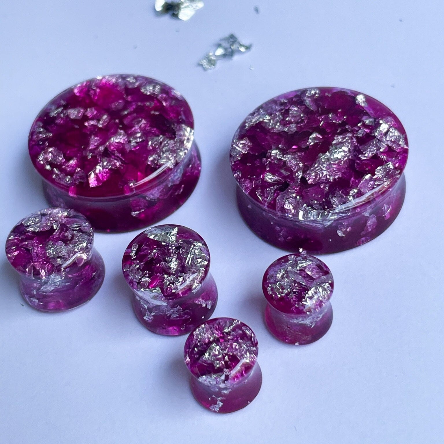 Dark pink resin ear gauges with gold colour flakes