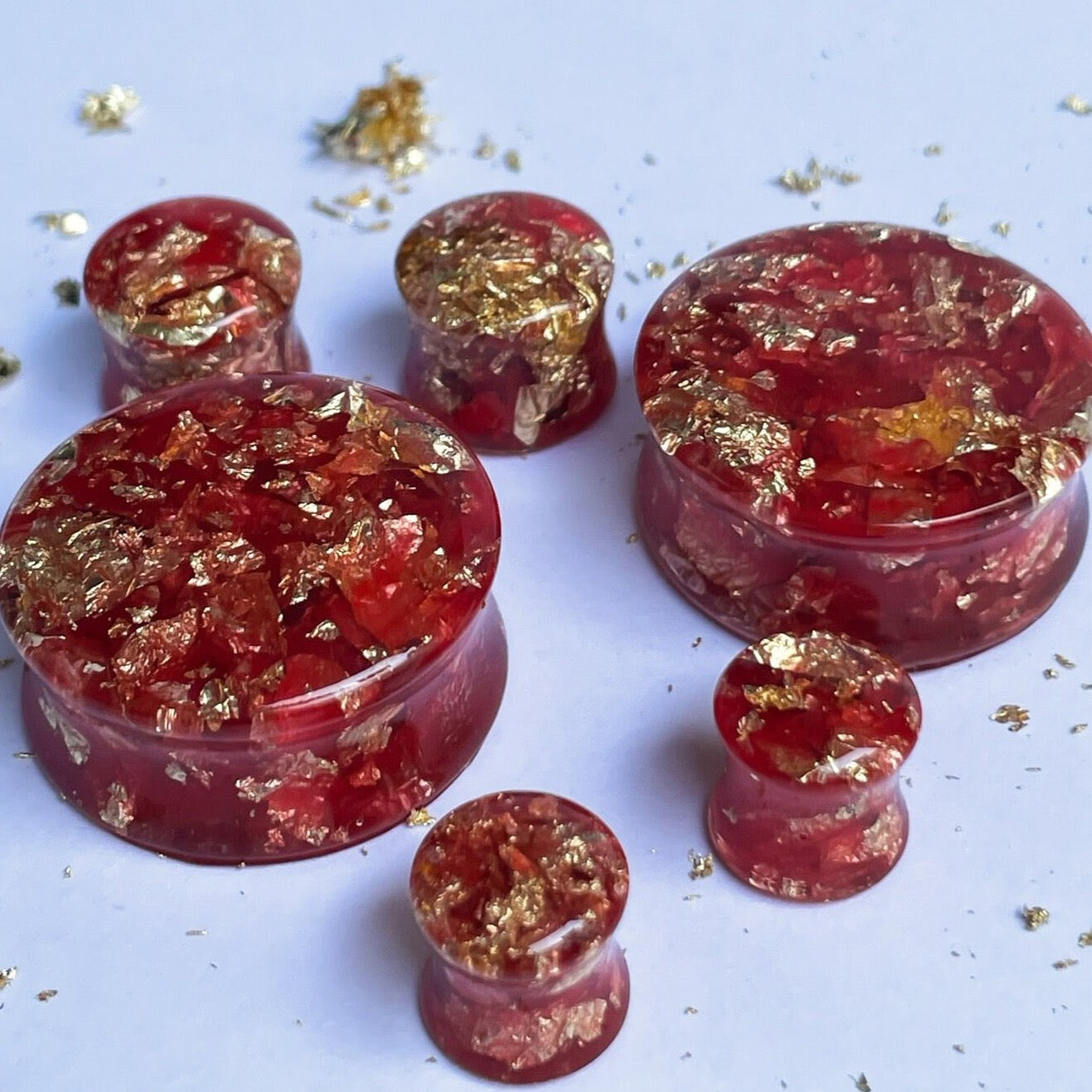 Red resin with gold colour flakes ear gauges